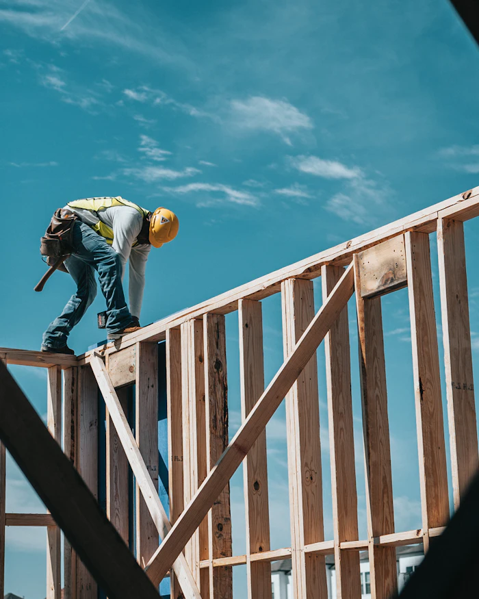 Construction worker in a hard hat on a timber building frame